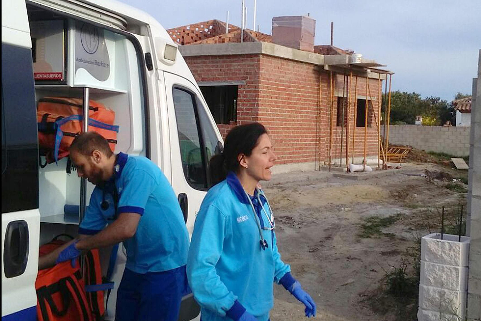 Personal de la UVI móvil y al fondo la casa en una zona sin regularizar del término chiclanero.