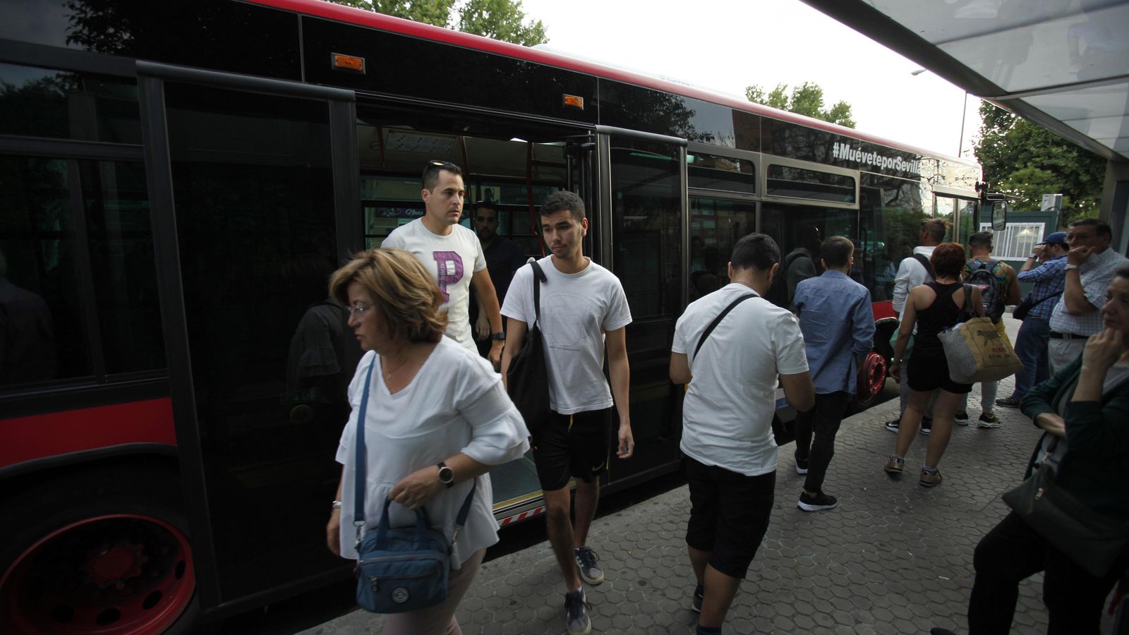 Varios viajeros suben y bajan de uno de los vehículos de la flota de Tussam.