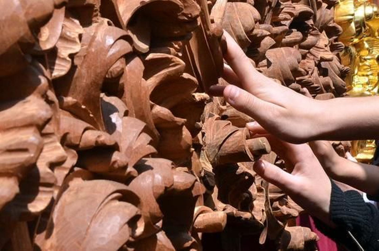 Tocar para ver. Manos de cofrades que no pueden reprimir tocar la madera aún sin dorar del paso de misterio del Soberano Poder.

Foto: Manuel Aranda