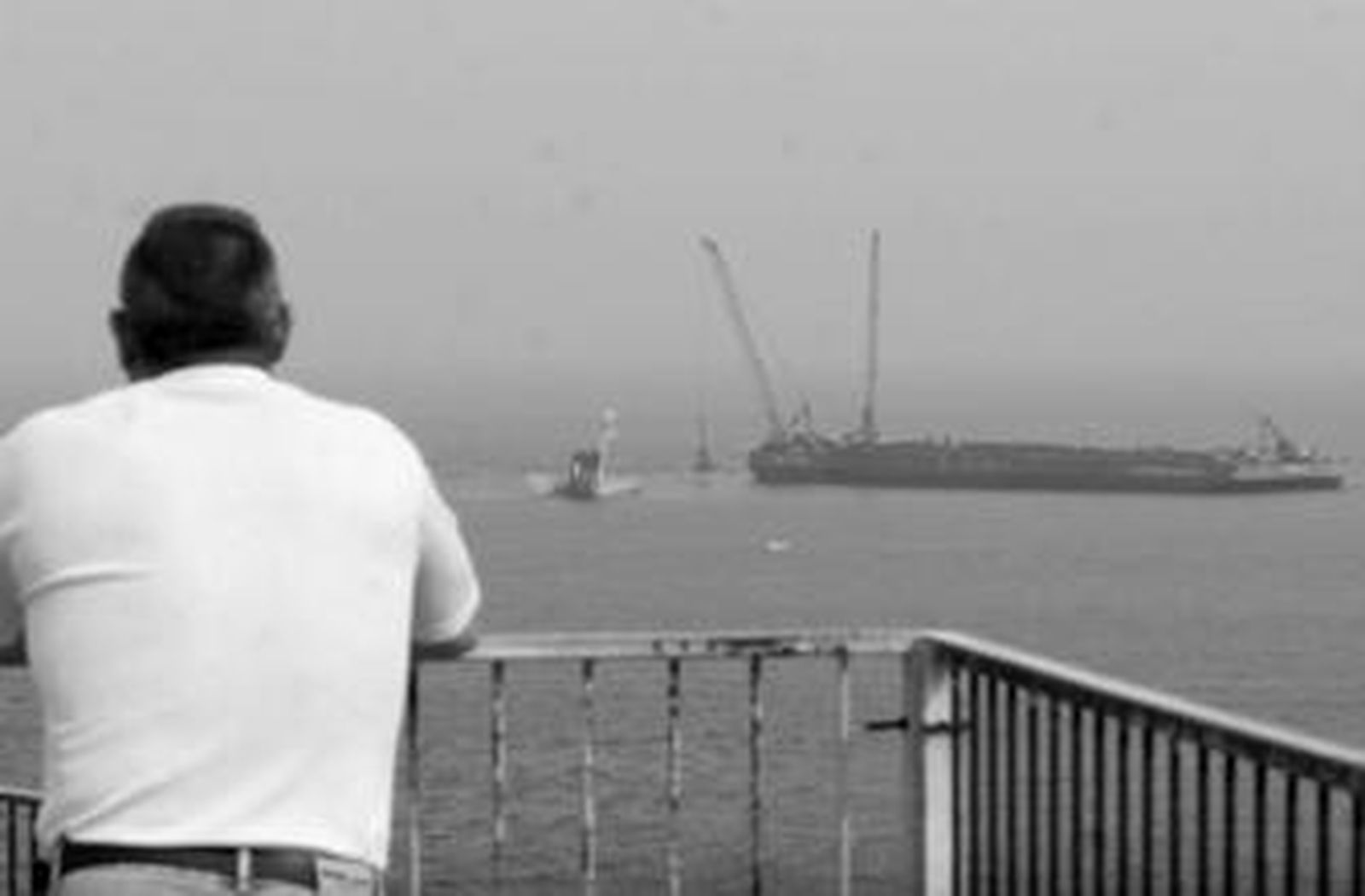 La grúa del 'Bigfoot 1' deja caer la chatarra rescatada de las bodegas del pañameno en su cubierta.