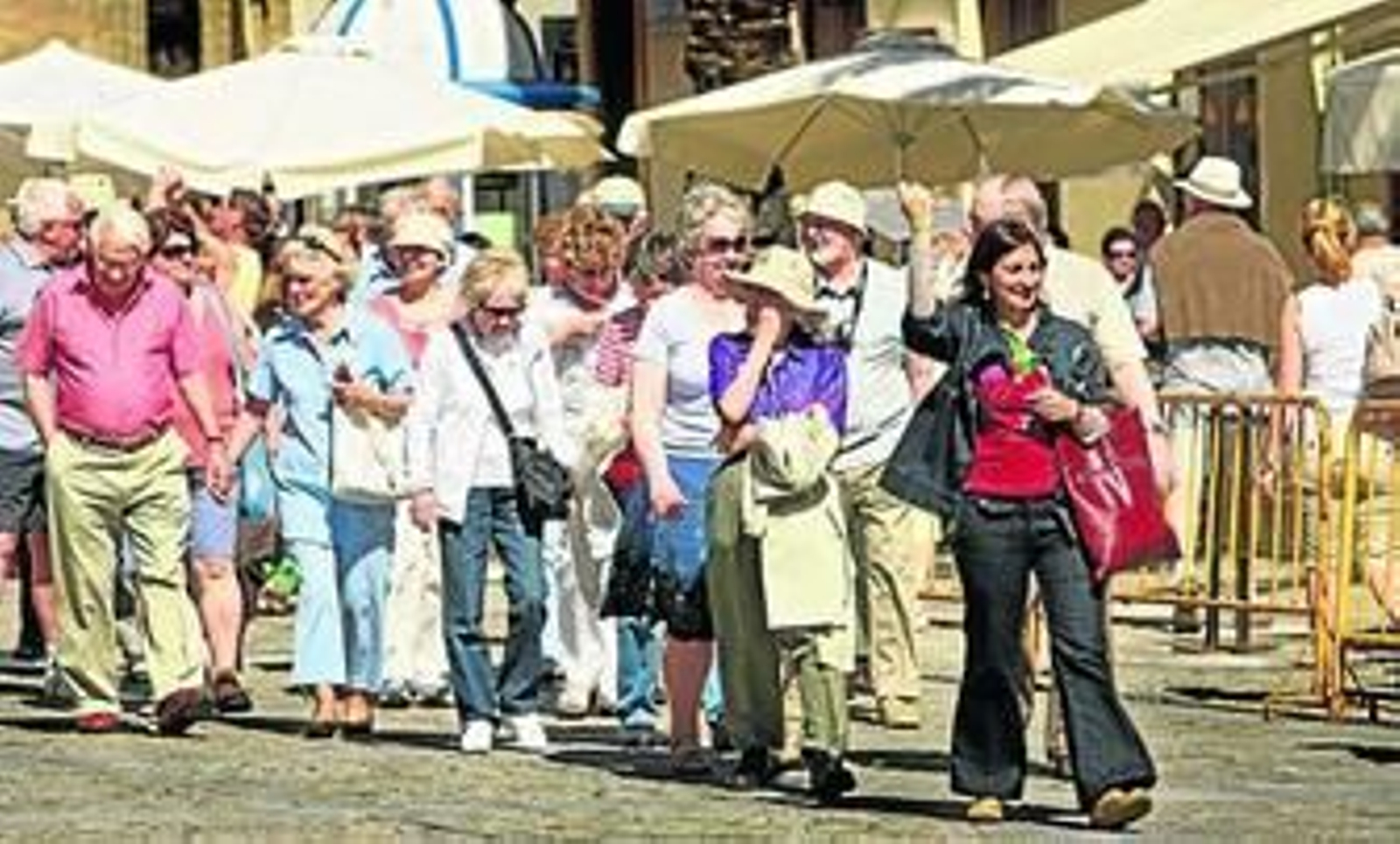 Un grupo de cruceristas sigue a una guía turística por la plaza de la Catedral.