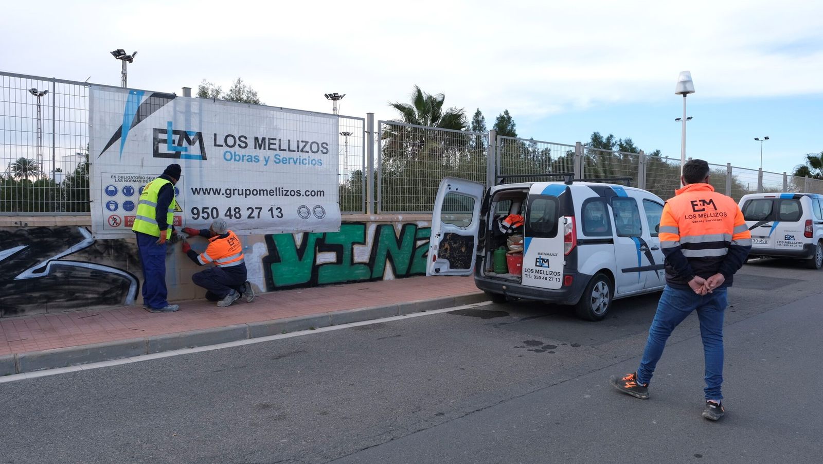 Trabajadores de la empresa adjudicataria colocan el cartel de obras.
