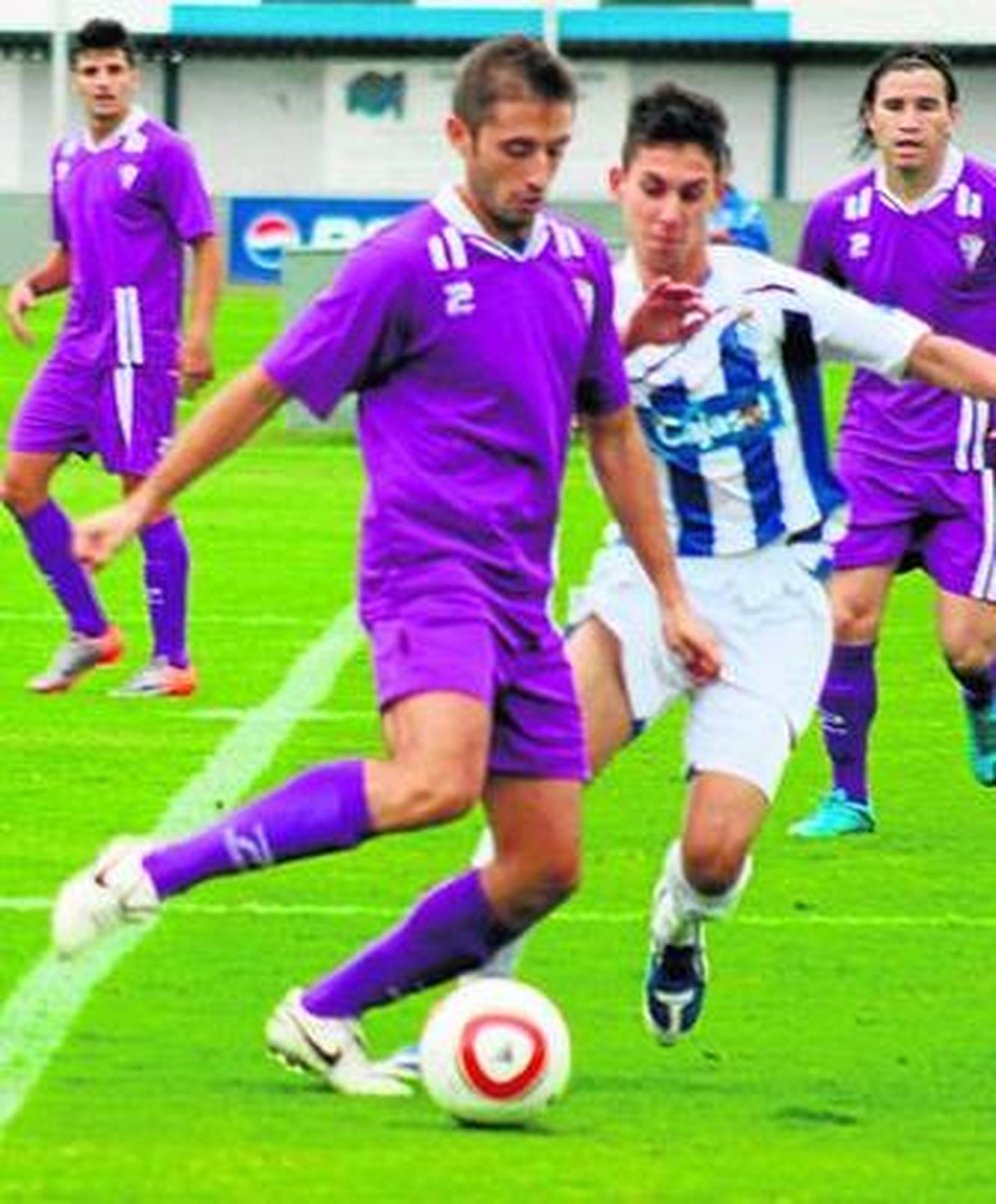 Rodiel toca la pelota en presencia de un rival.
