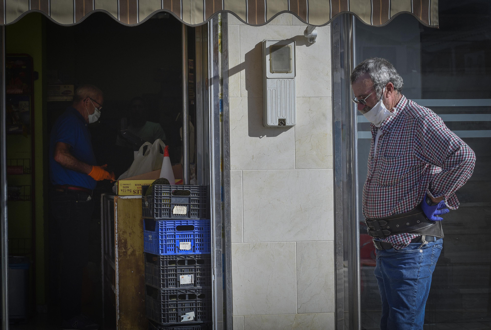 Un vecino pasa junto a un comercio, en una imagen tomada durante el confinamiento entre marzo y junio.