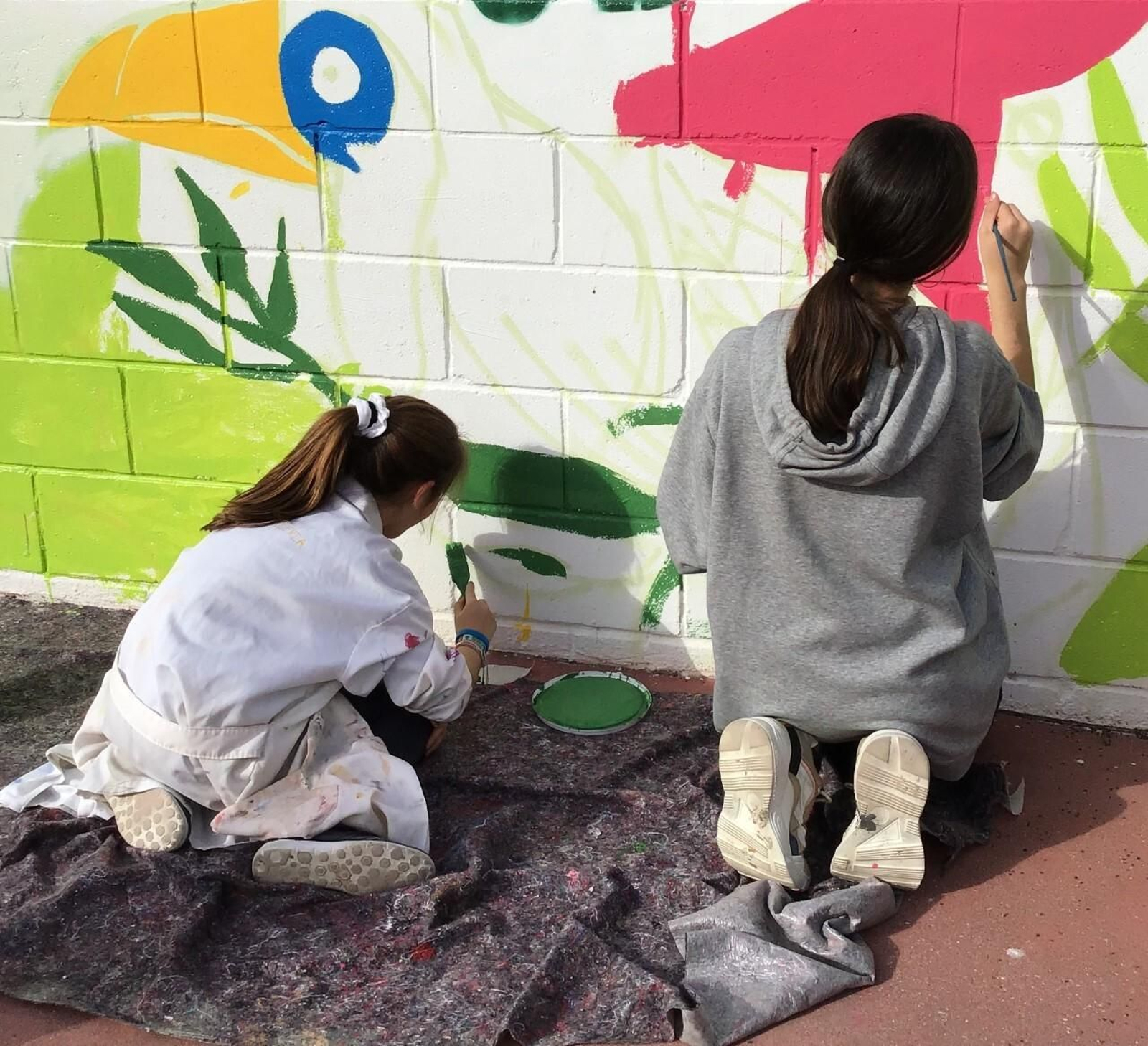 Dos niñas pintan un mural en una de las actividades de Espacio de Dentro. Dos niñas pintan un mural en una de las actividades de Espacio de Dentro.