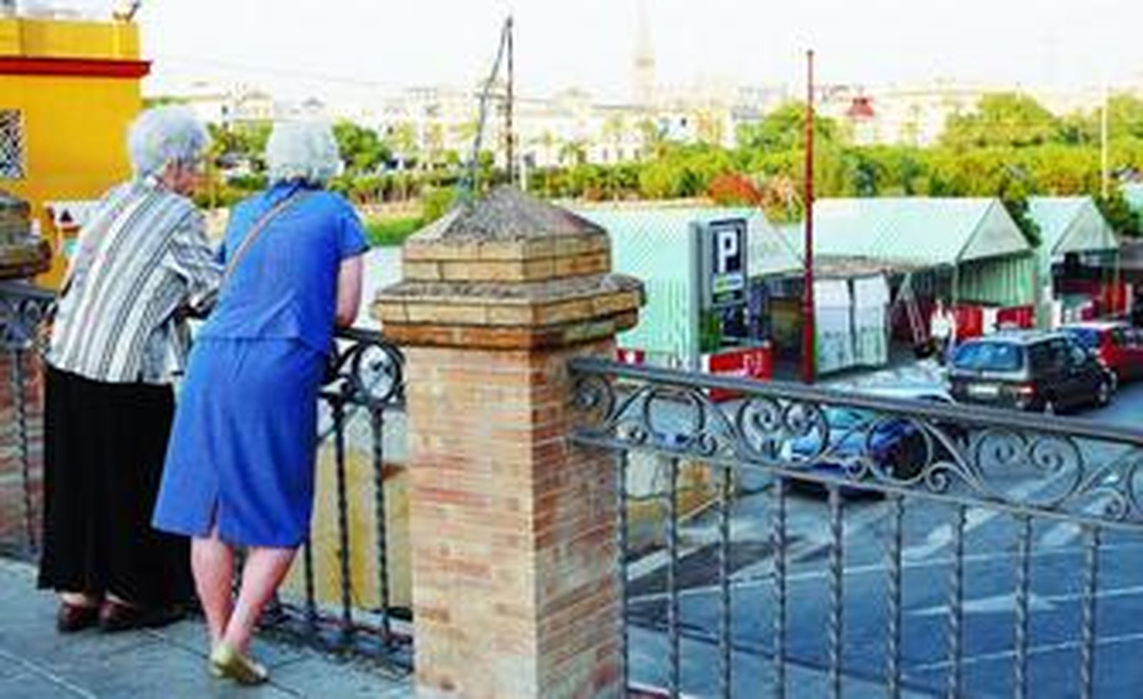 Dos mujeres observan los últimos preparativos de la tradicional Velá de Santiago y Santa Ana.
