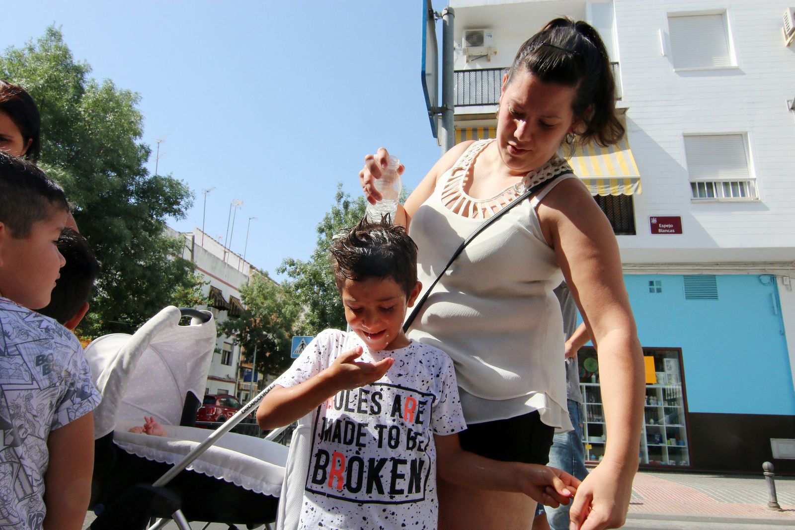 Una madre refresca a su hijo antes de entrar al colegio.
