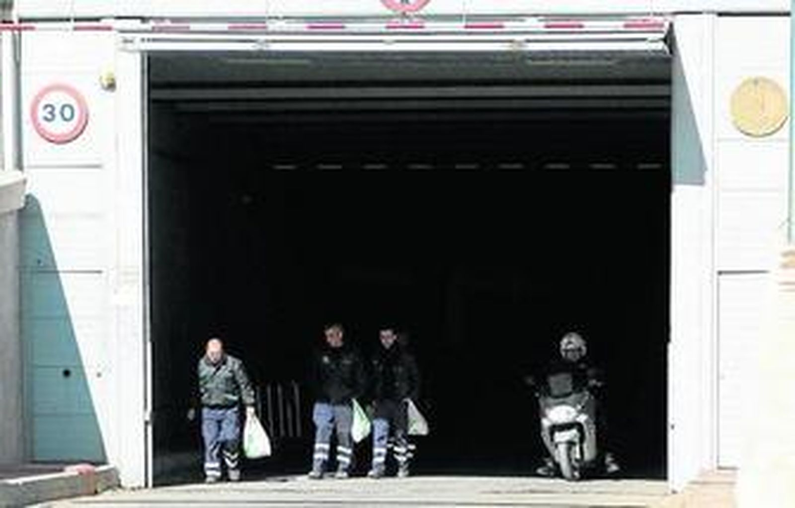 Compañeros del trabajador herido salen del túnel sur, a mediodía de ayer.