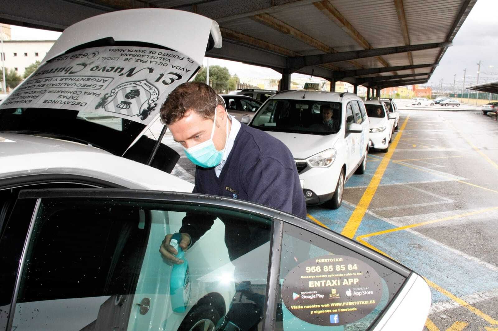 Un taxista desinfectado su vehículo.