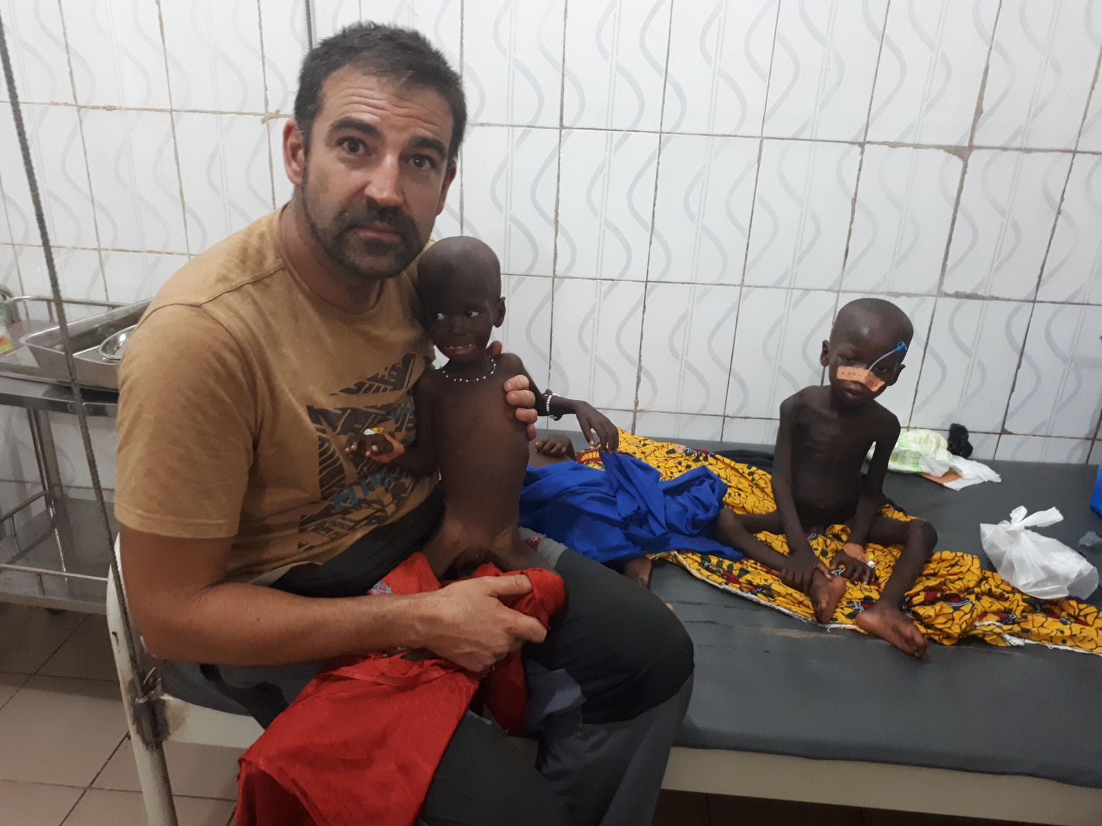 Gilberto Morales sostiene a  Sekou, un niño que sufrió desnutrición y que hoy está sano.