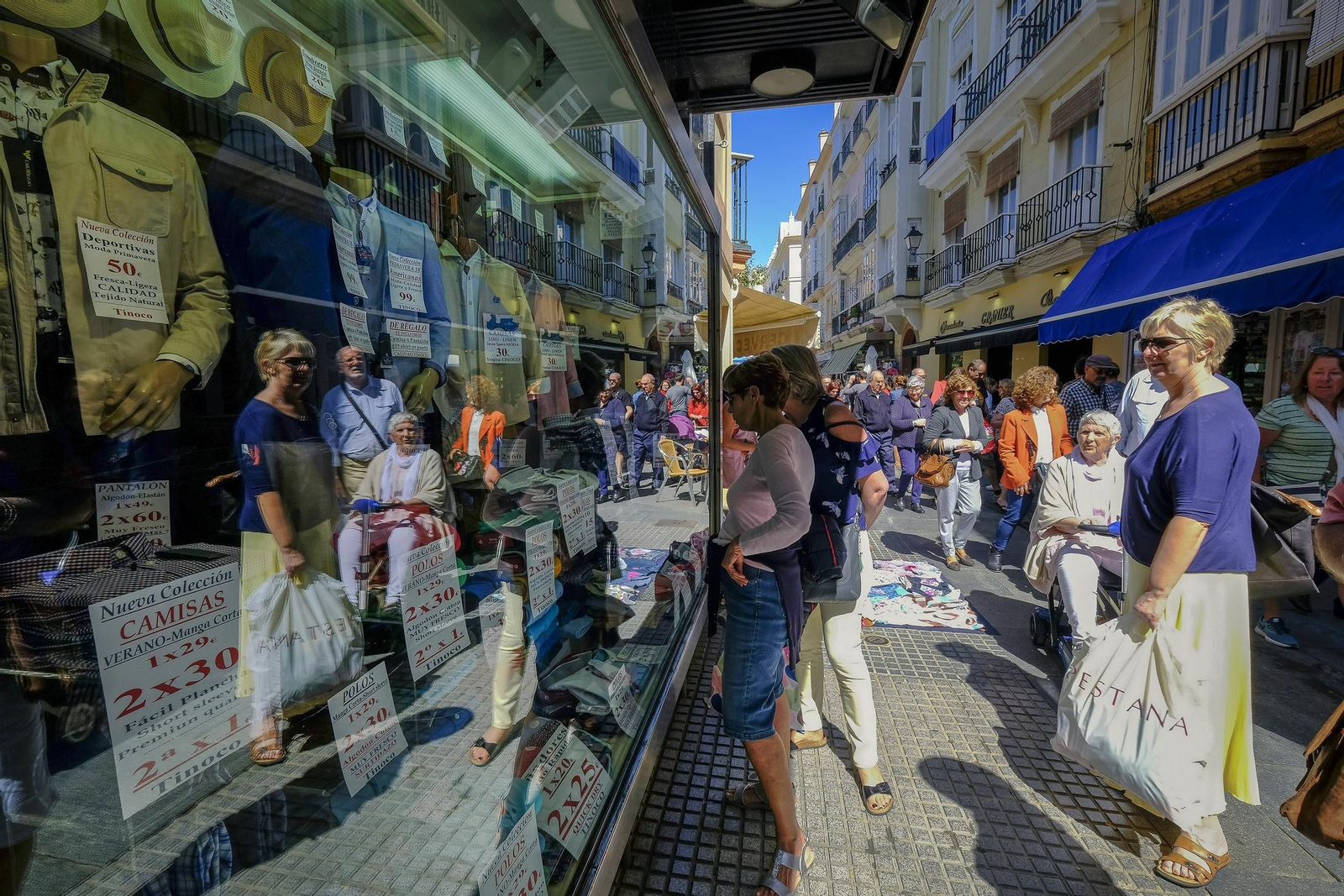 Varios turistas observan un escaparate de un comercio en la capital gaditana.