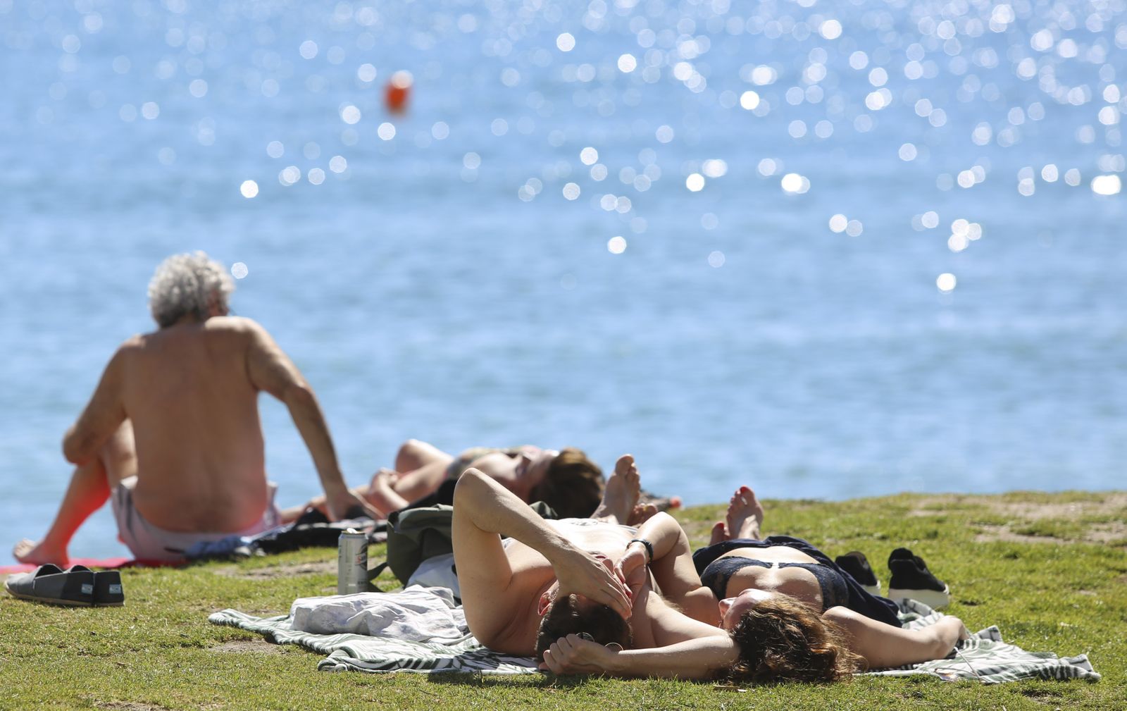 Un grupo de personas toman el sol en la playa