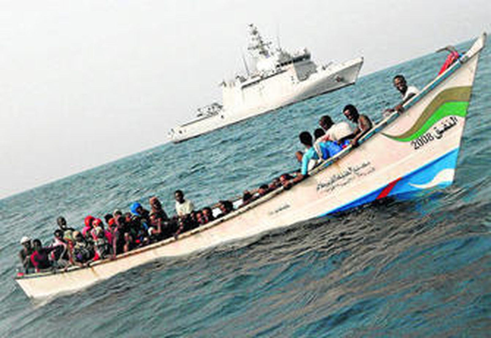 La embarcación con más de 50 personas a bordo, justo antes de ser rescatada por el 'Relámpago' (detrás).