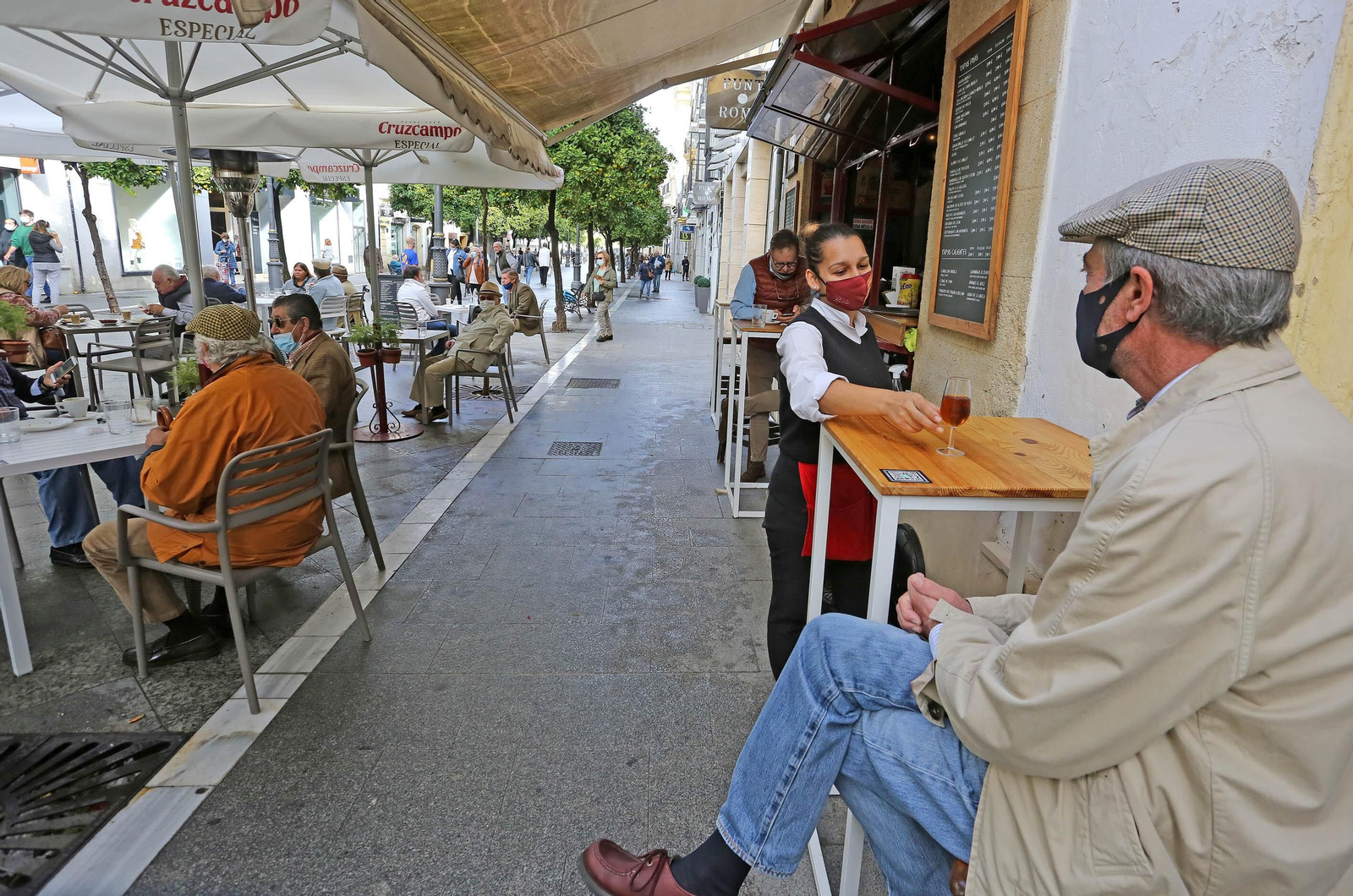 Un cliente de un bar del centro consume una copa de jerez con la mascarilla puesta.