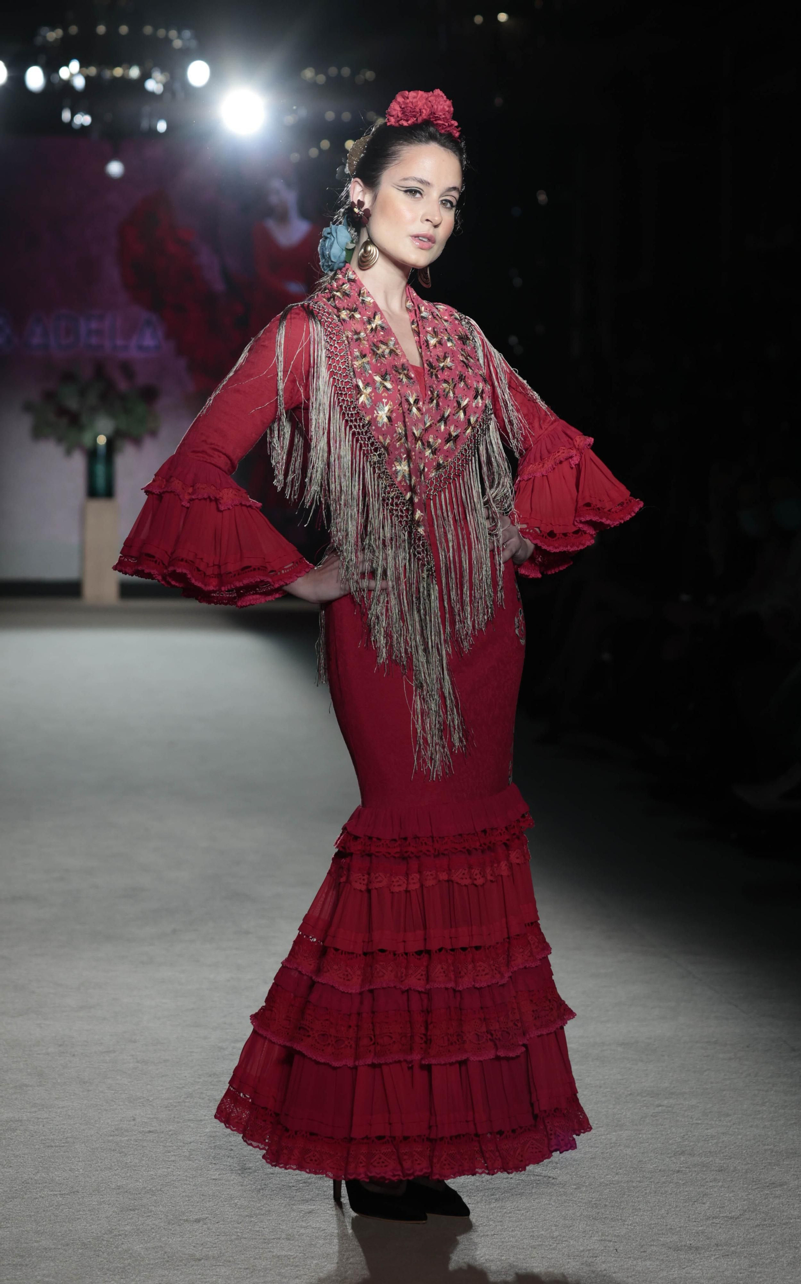Traje de flamenca rojo con un mantoncillo de flores de Ángela y Adela. Traje de flamenca rojo con un mantoncillo de flores de Ángela y Adela.