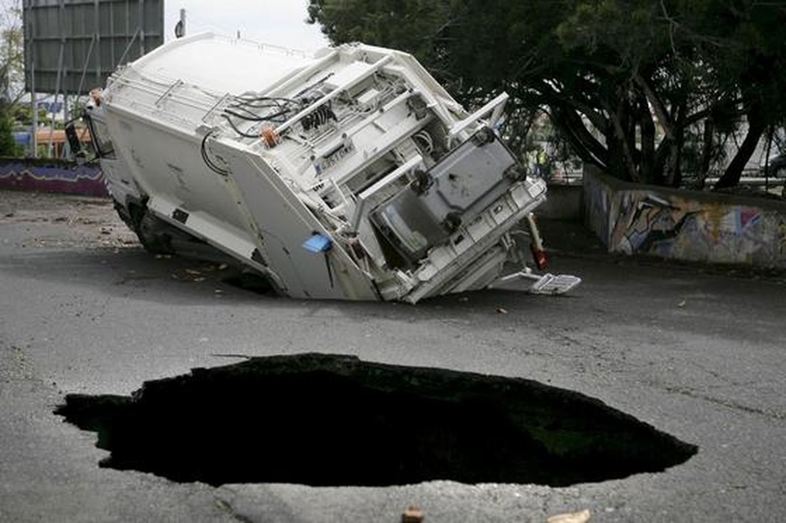 Un camión de recogida de basura atrapado en uno de los boquetes ocasionados por las fuertes lluvias caídas en Tenerife. 

Foto: Cristóbal García (Efe)