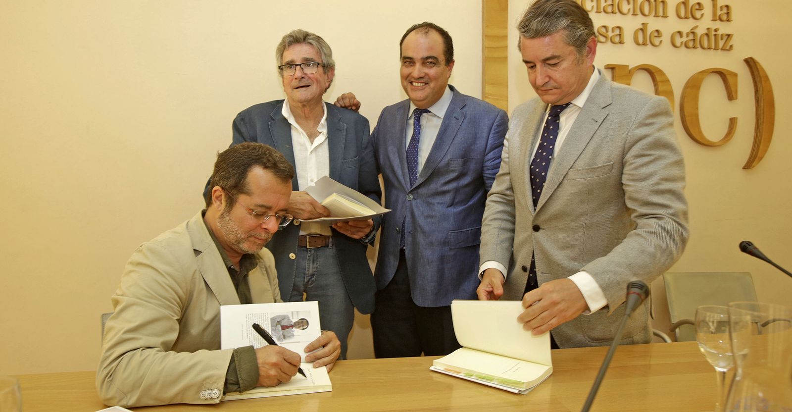 Juan Manuel Marqués firma un ejemplar de su libro en presencia de Luis Pizarro, David Fernández y Antonio Sanz.