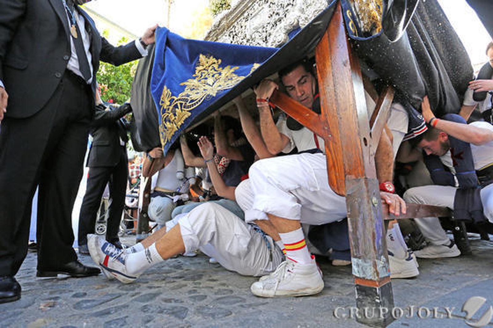 Los 'hombres de abajo' del paso de misterio de Cristo Rey, en pleno relevo tras la díficil salida desde el colegio de San José.  Foto: Pascual