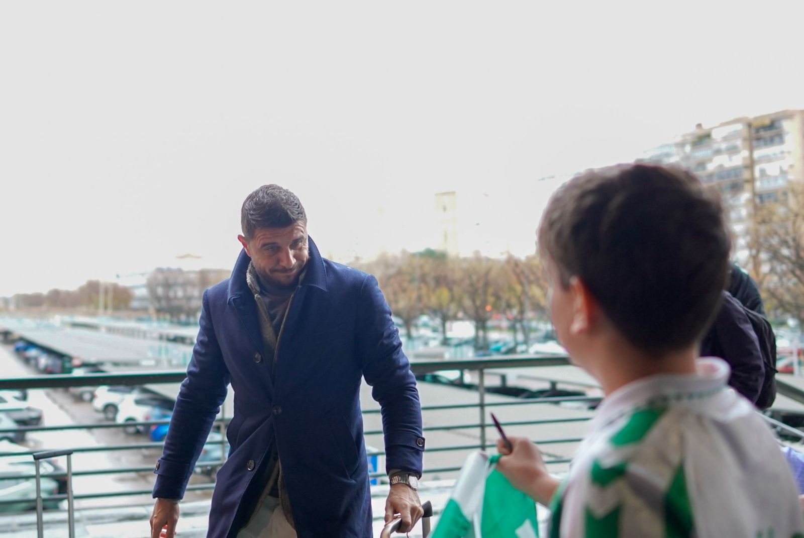 El consejero del Betis, Joaquín Sánchez, se disopone a firmarle un autógrafo a un joven hincha bético.