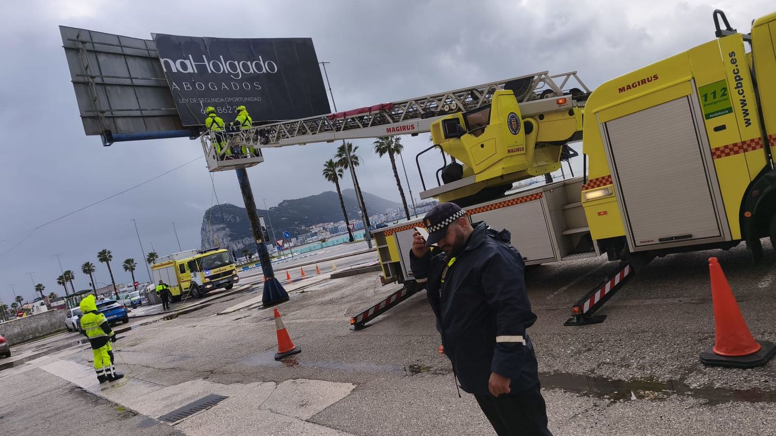 Los bomberos, en el momento de retirar el cartel.