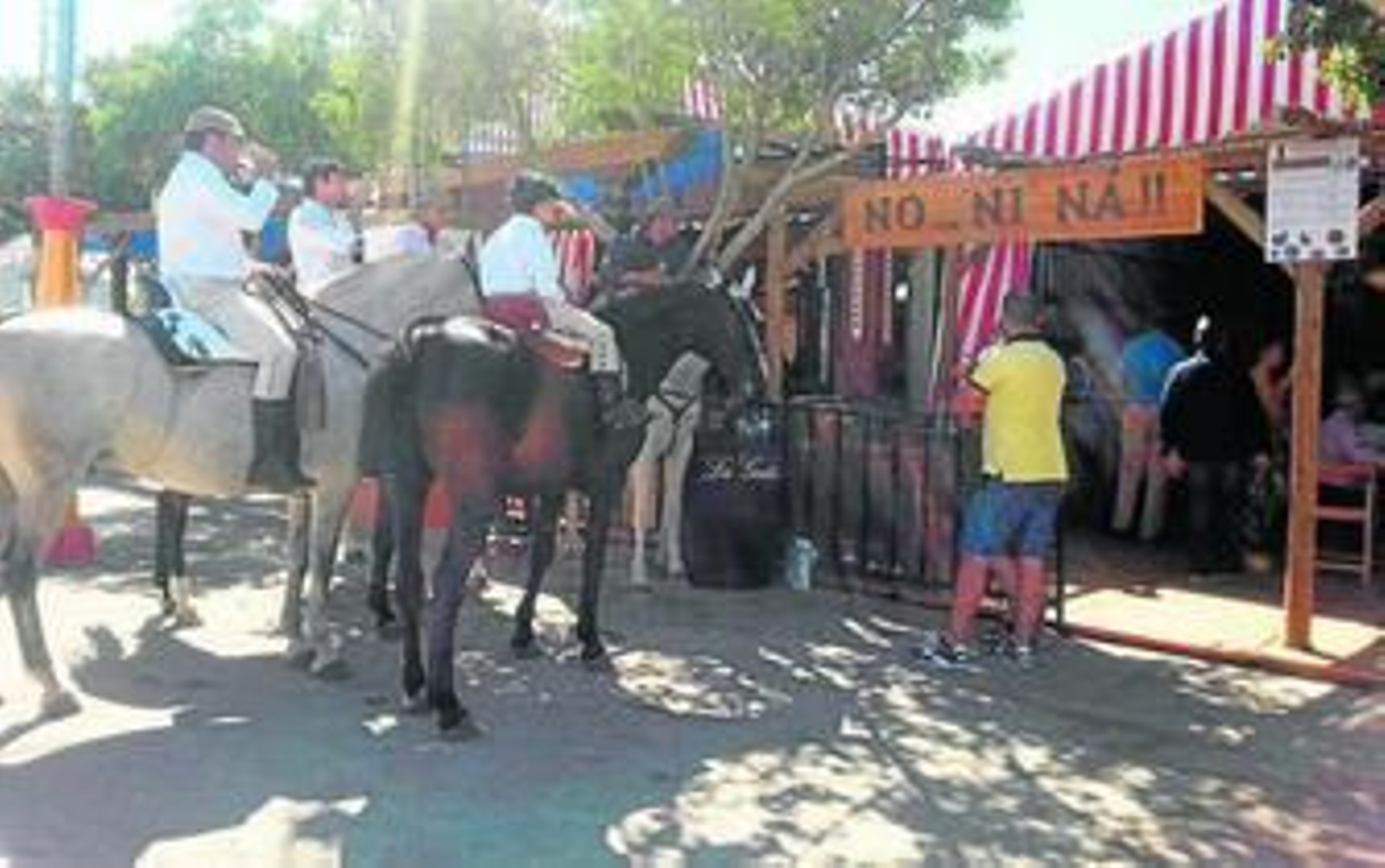 Un grupo de jinetes, a lomos de los caballos pasea por el recinto ferial.