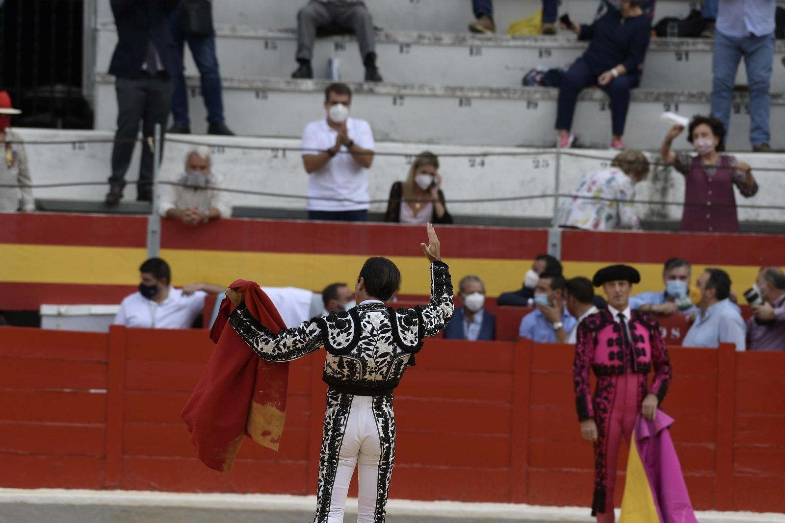 Ana Soria, al fondo, con mascarilla, siguiendo la faena en directo.