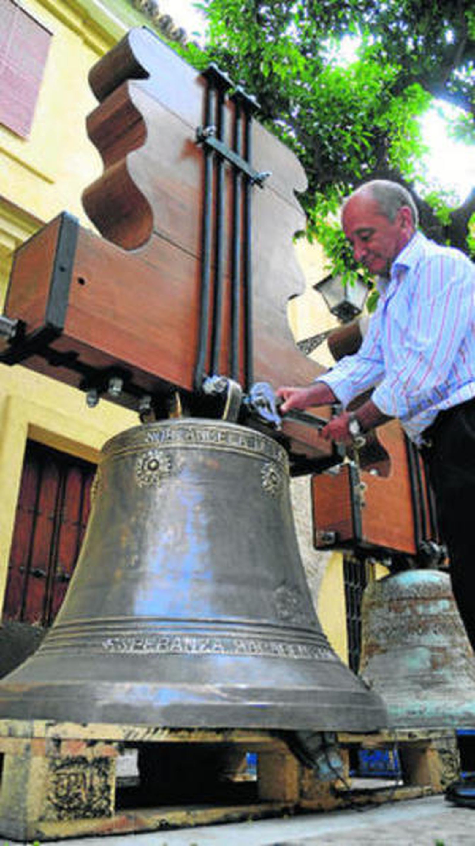 1. El campanero, Antonio Mendoza, ajusta las tuercas de la campana Sor Ángela de la Cruz en el Patio de los Naranjos del Salvador 2 y 3. Las campanas, ya restauradas, han estado los últimos días expuestas en el taller que los Mendoza tienen en la Colegial del Salvador. 4. La mayor de las campanas, Sor Ángela de la Cruz lleva grabada la leyenda: 'Esperanza Macarena ruega por nosotros'. 5. Una cabrilla, a modo de firma, en la campana.