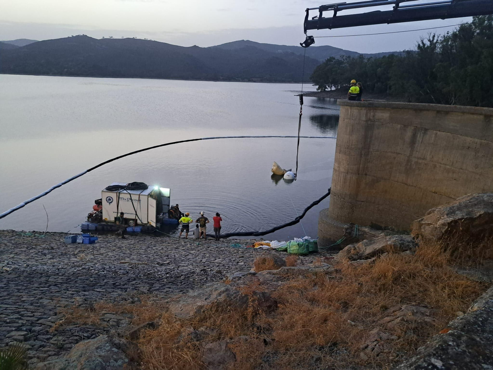 Las tareas de reflotamiento junto al muro del pantano.