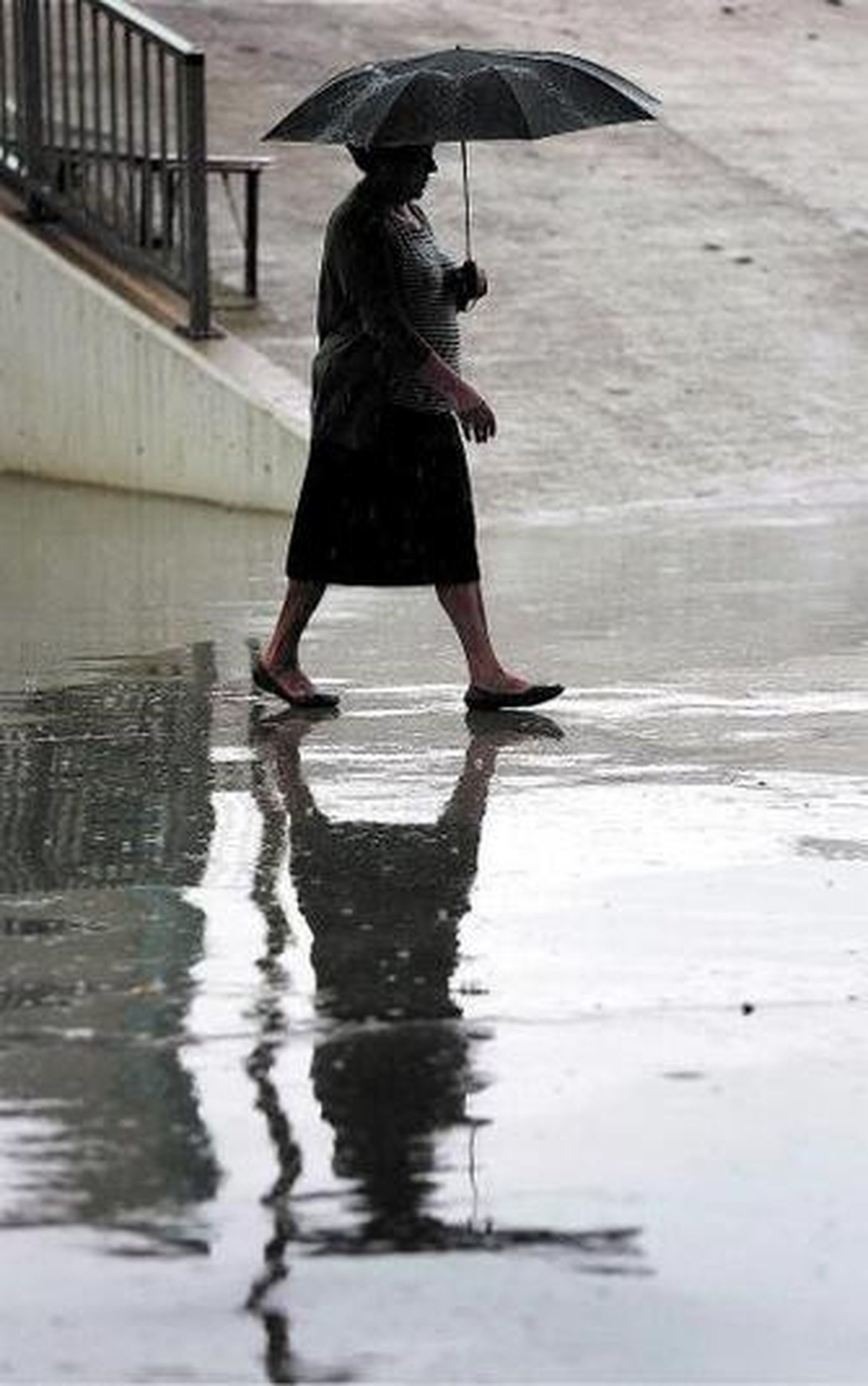 Una mujer camina bajo la lluvia en Málaga.