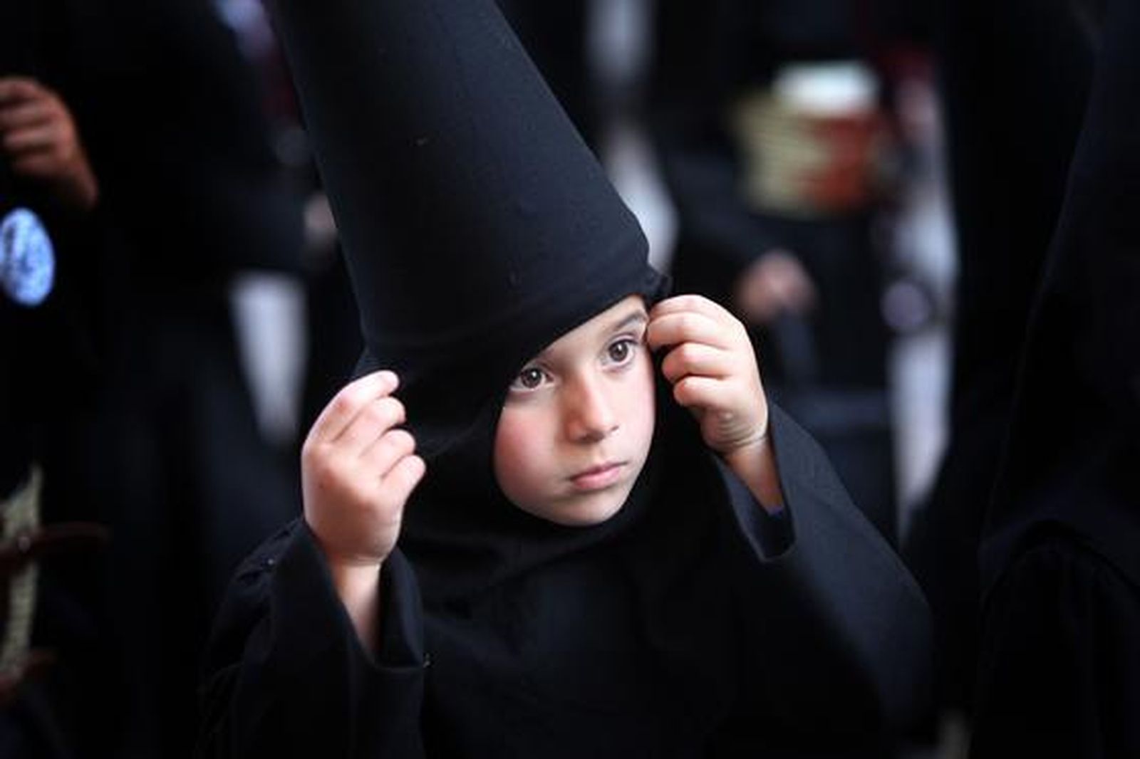 Un nazarenito de la hermandad de Las Angustias se ajusta la túnica de su descubierto antifaz.

Foto: vanesa lobo