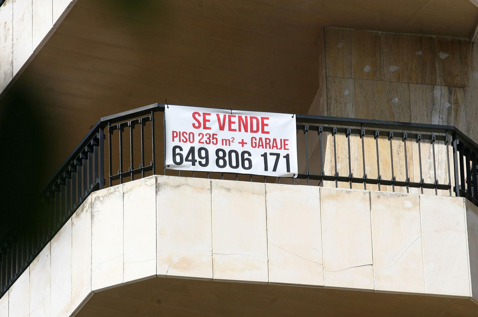 Imagen de un cartel de 'Se Vende' en el balcón de un edificio