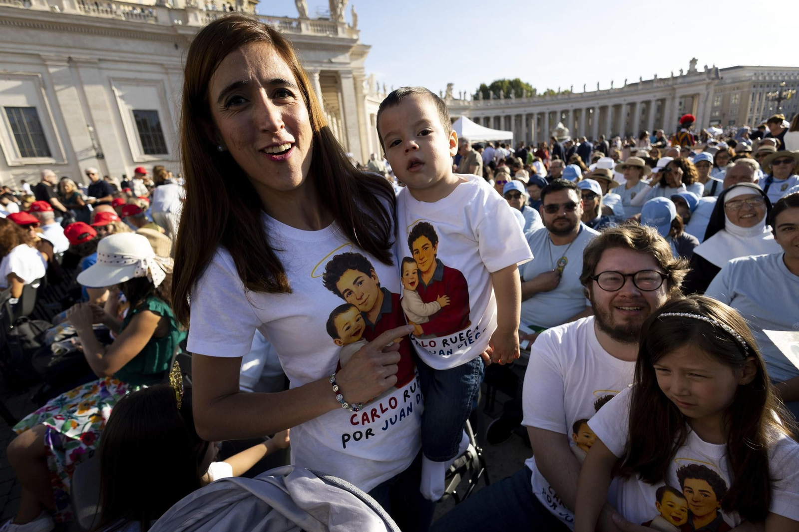 Una peregrina con un niño en brazos acude a la plaza de San Pedro para la canonización de Carlo Acutis.