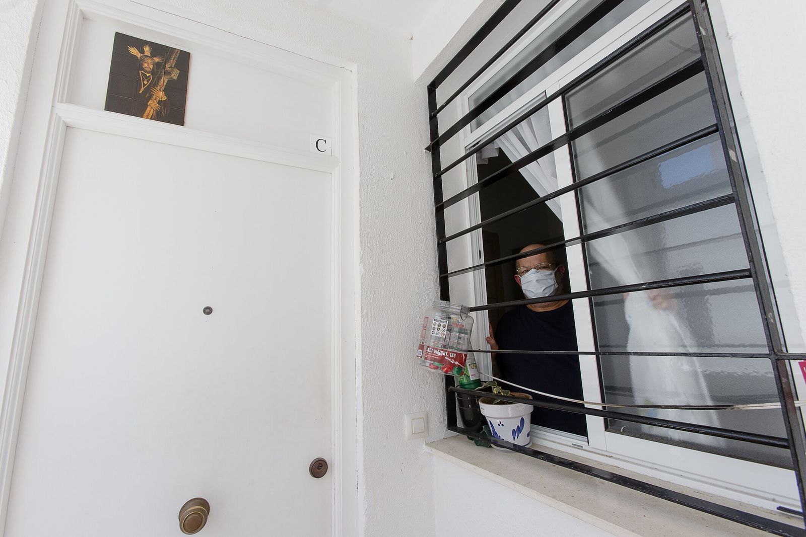 Diego Gutiérrez se asoma por una enrejada ventana de su vivienda.