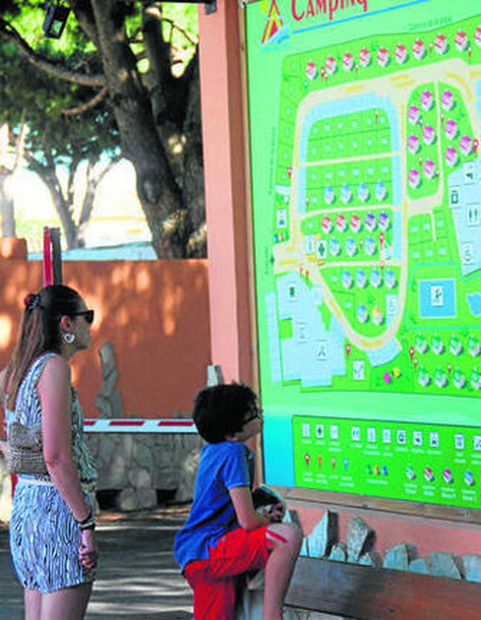 Unos turistas observan el plano del camping Caños de Meca, ubicado en esa población de Barbate.