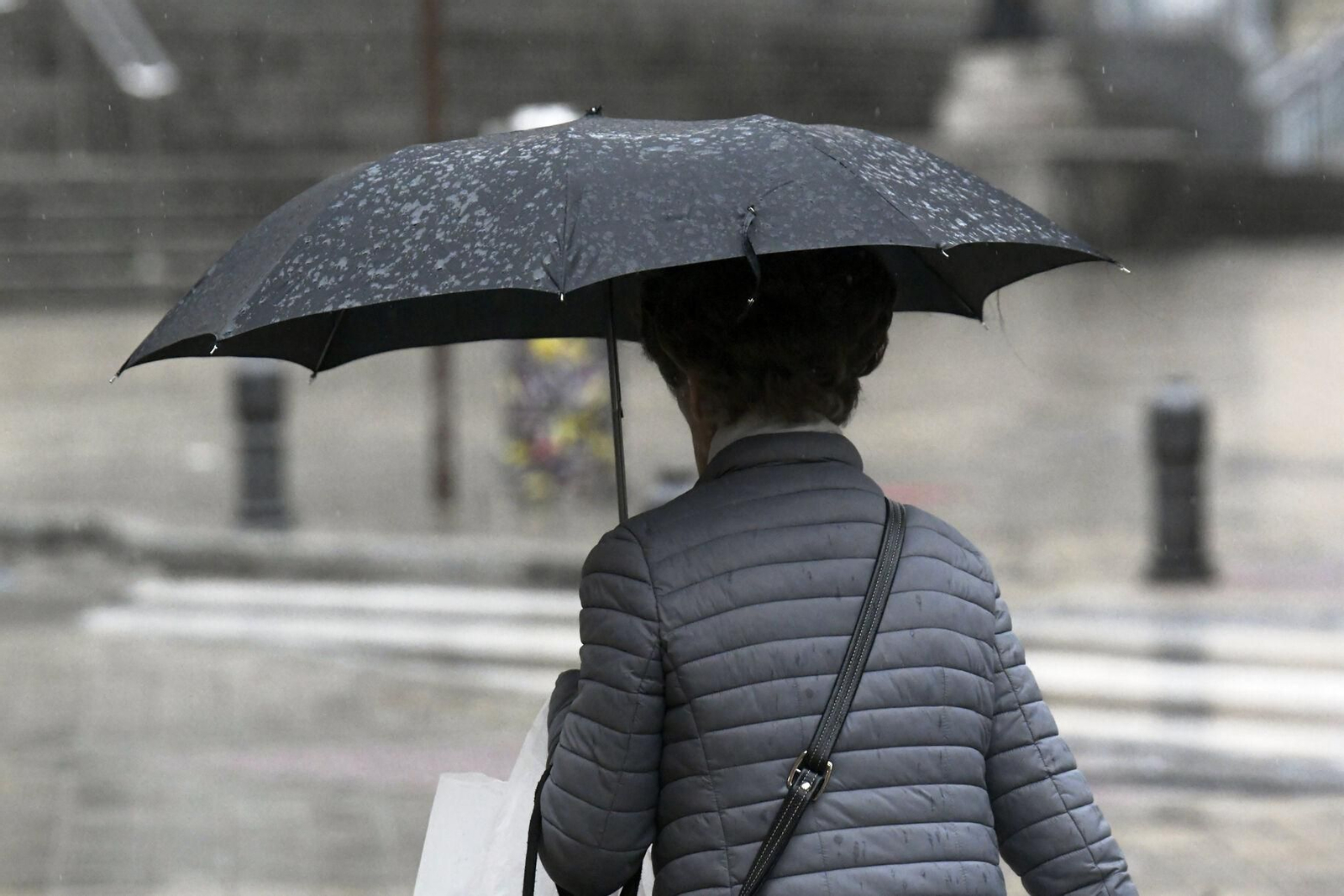 Una persona se protege de la lluvia con un paraguas en Granada.