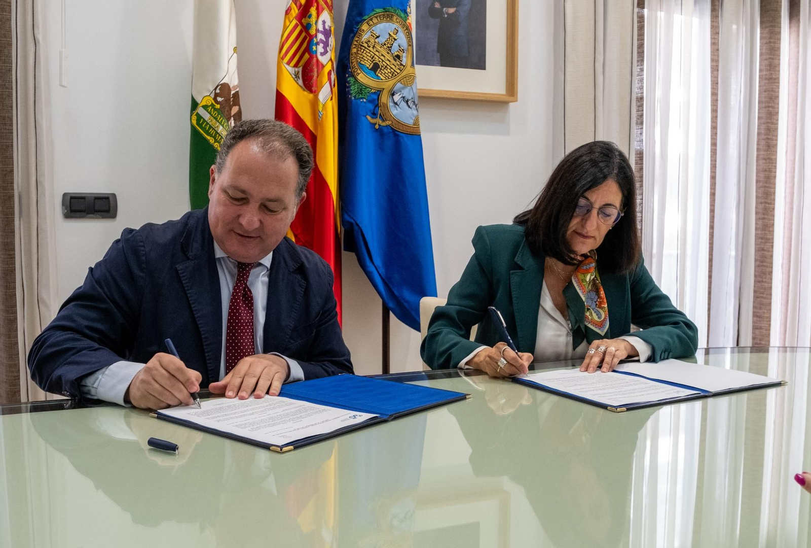 El presidente de la Diputación, David Toscano, y la rectora de la UHU, María Antonia Peña, firmando el acuerdo.