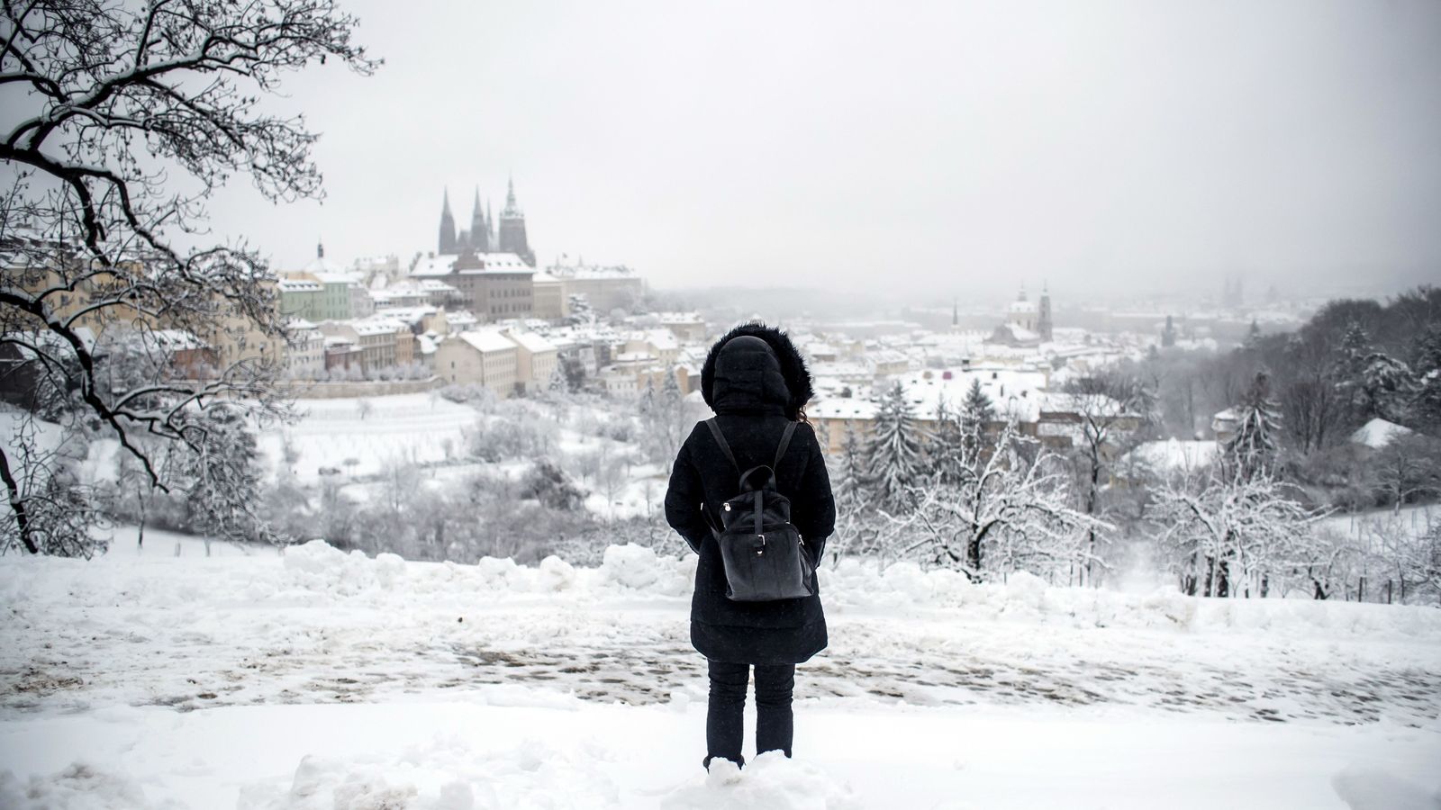 Una mujer divisa el castillo de Praga cubierto de nieve tras la nevada sufrida en la capital checa.