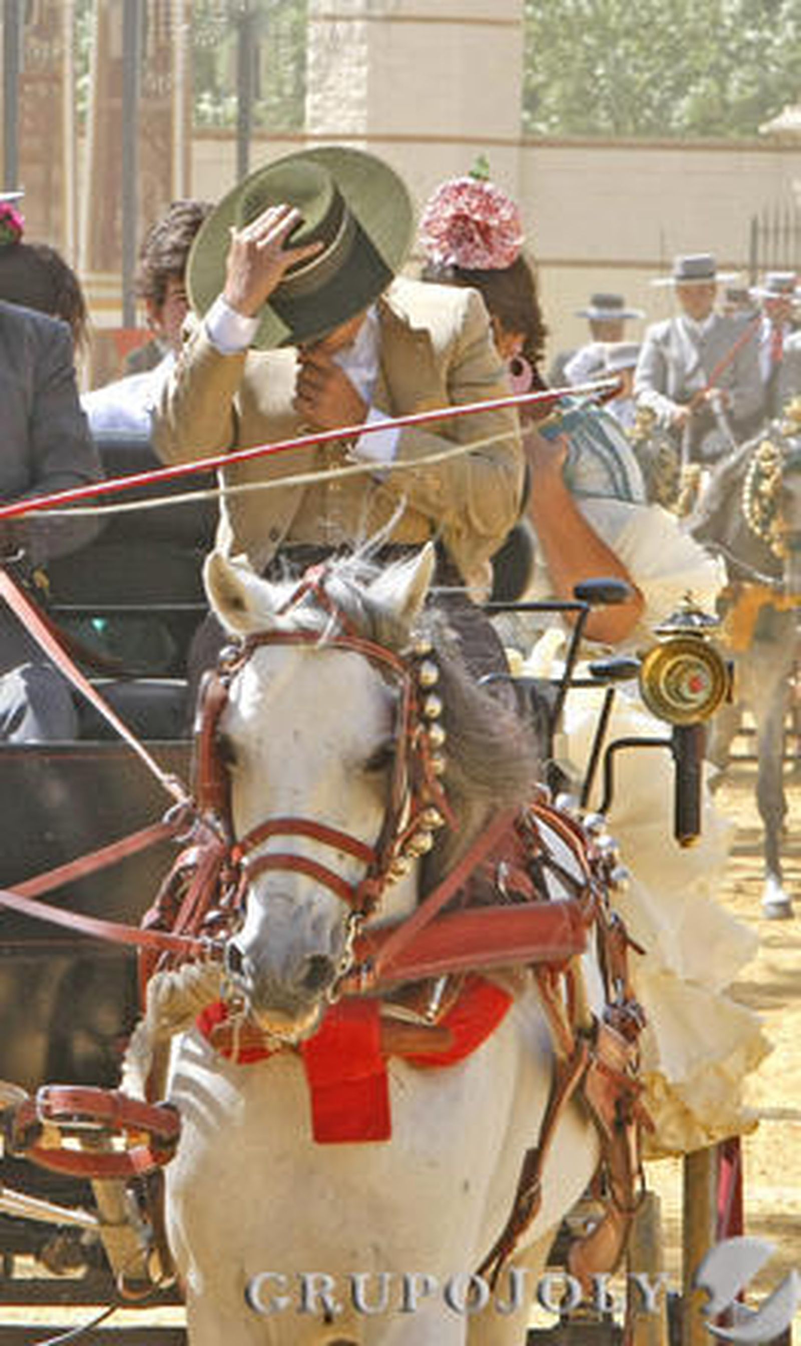 Un cochero se protege la cara con su sombrero del fuerte viento.

Foto: Pascual