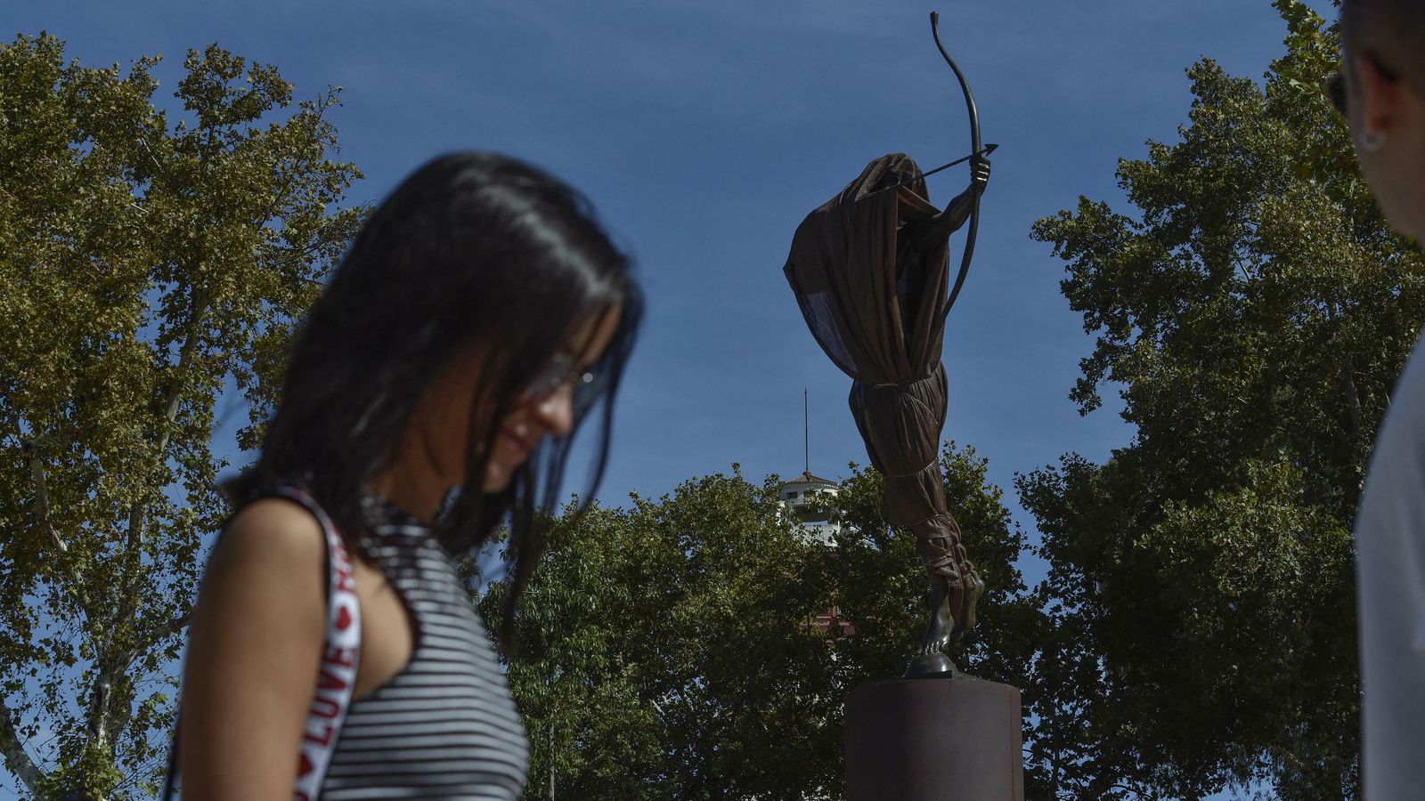 Una joven pasa ante la escultura.