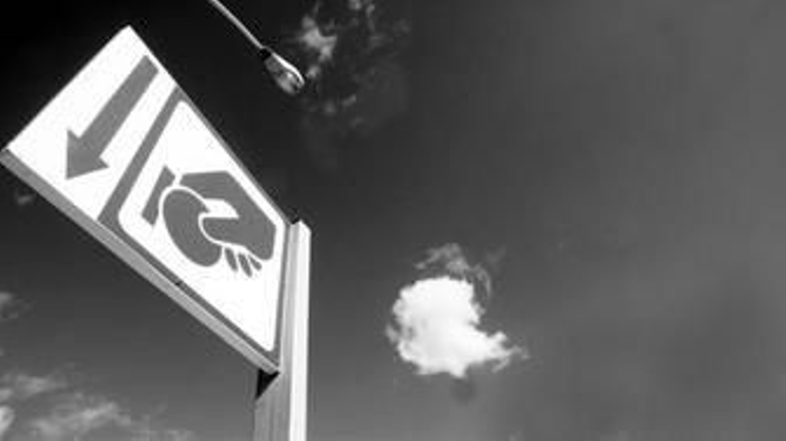 Un cartel avisa de la ubicación del parquímetro para abonar el estacionamiento en zona azul.