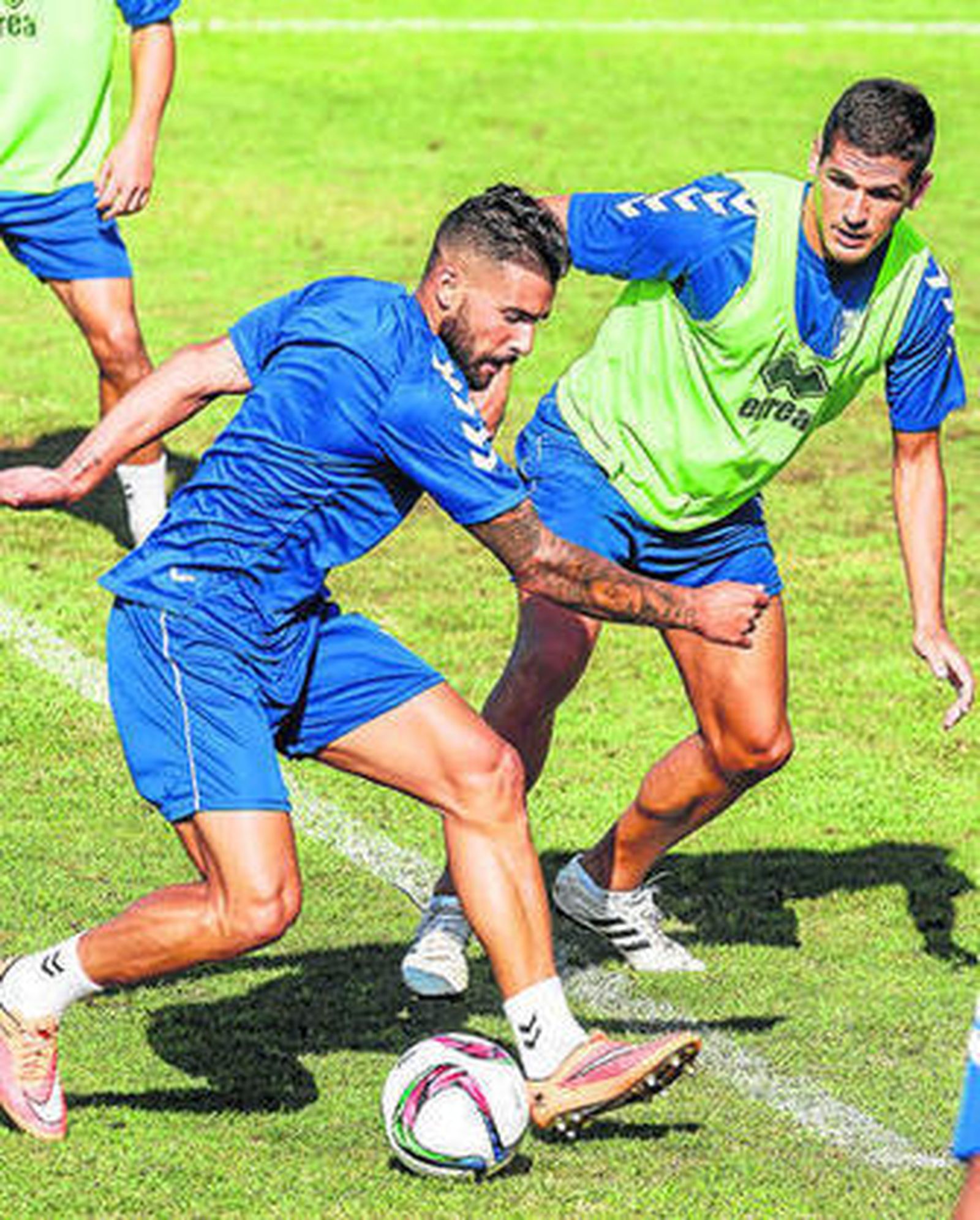 Cristian Márquez se dispone a golpear el esférico durante una sesión acosado por Garrido.