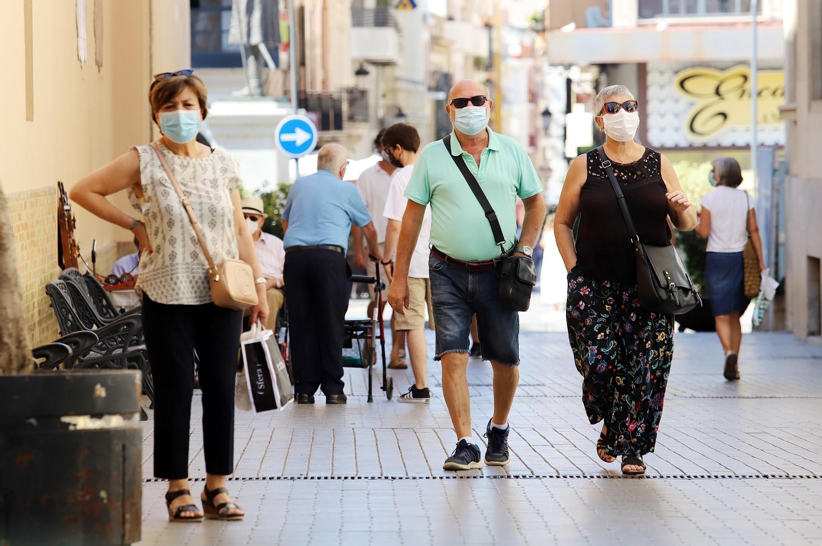 Gente paseando con mascarillas.