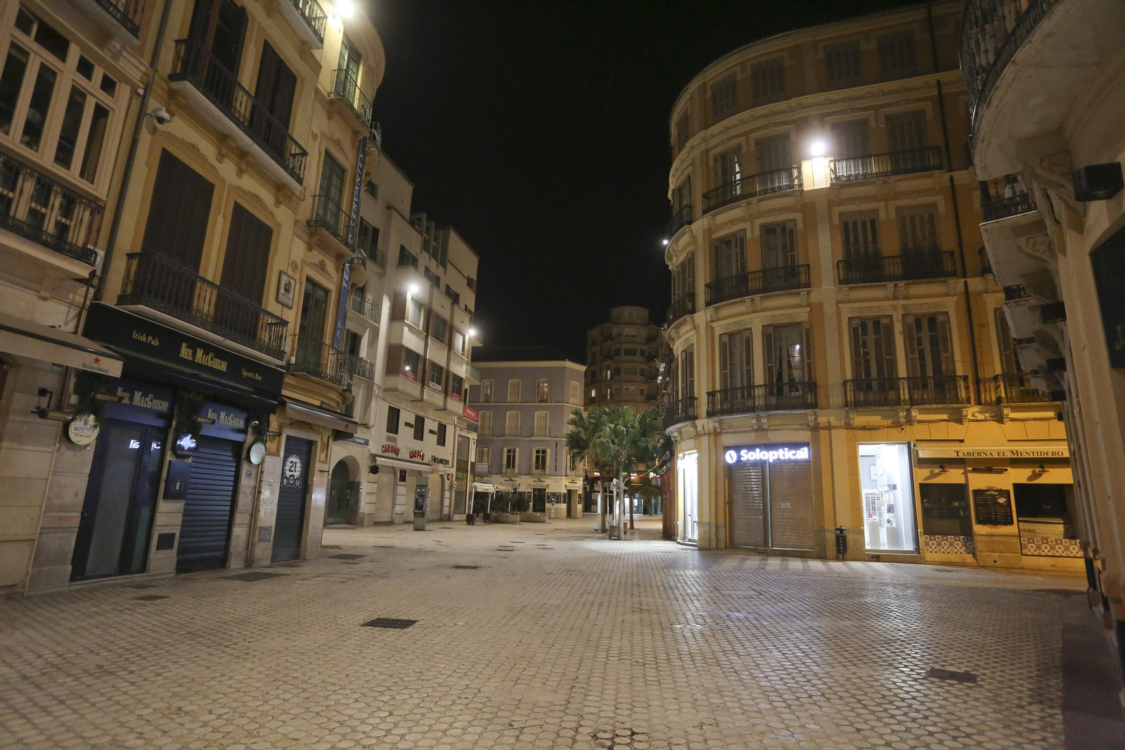 El coronavirus dibuja una noche desierta en el centro de Málaga, en fotos