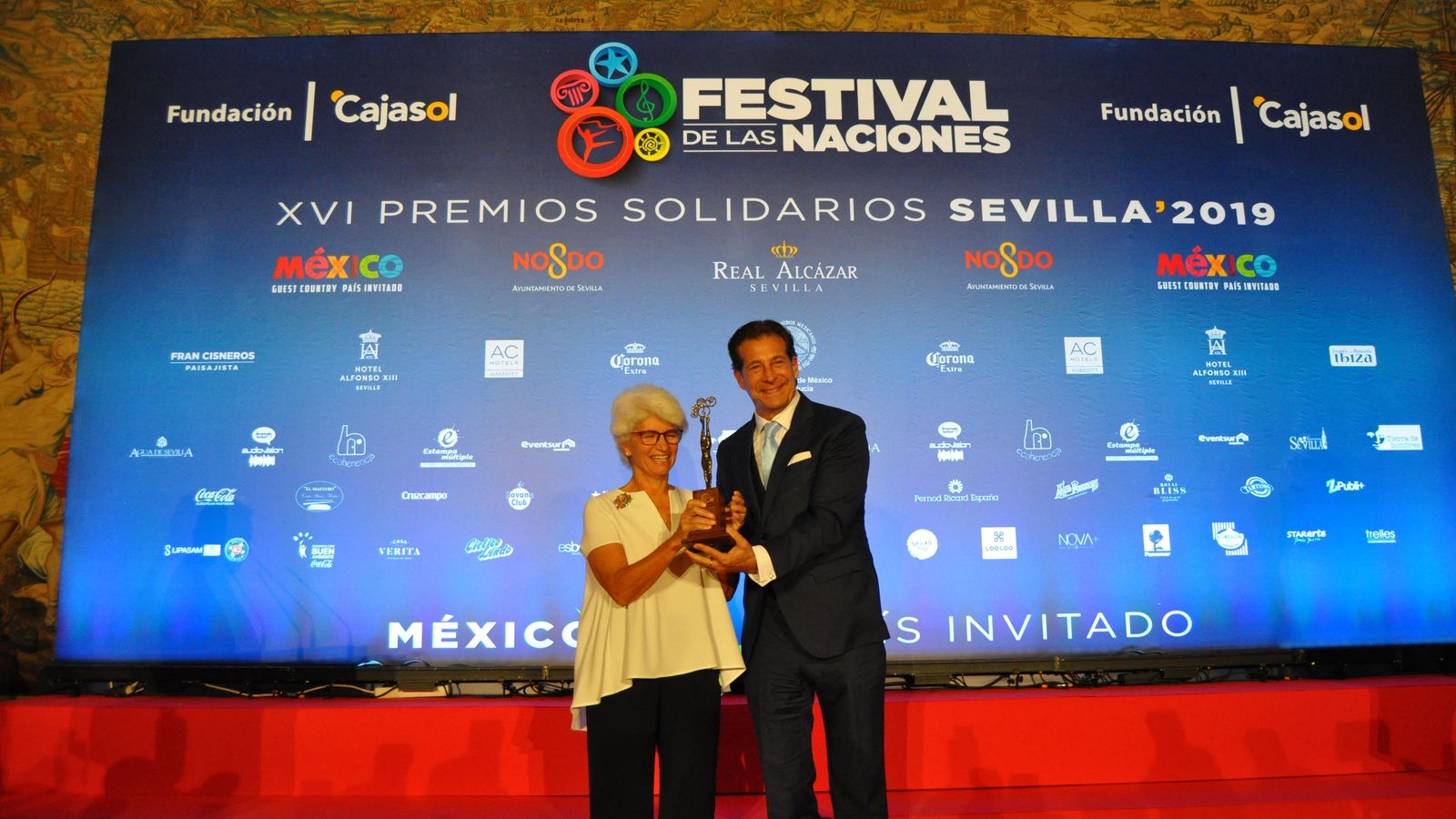 Marisa Caprile, presidenta de PSE España, recibe el premio de manos de Sergio Frenkel, director general del Festival de las Naciones.