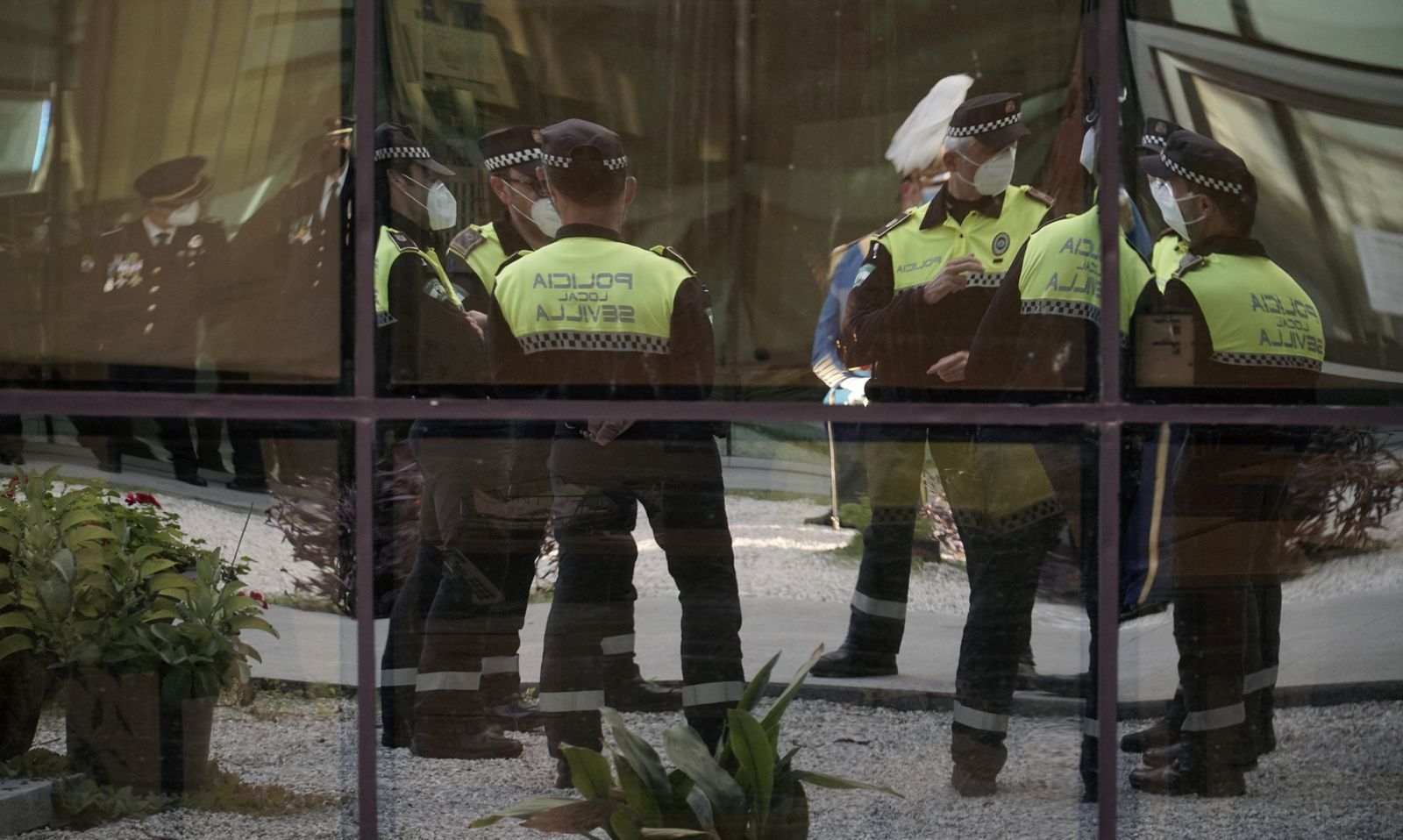 Policías locales de Sevilla, reflejados en un cristal de la Jefatura, durante los actos de San Clemente de 2020.