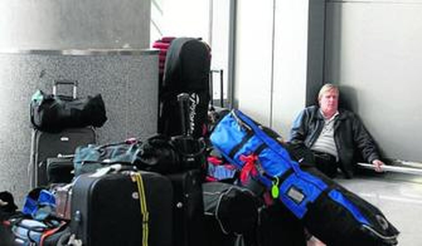 Un pasajero, el sábado, en el aeropuerto, rodeado de equipaje.