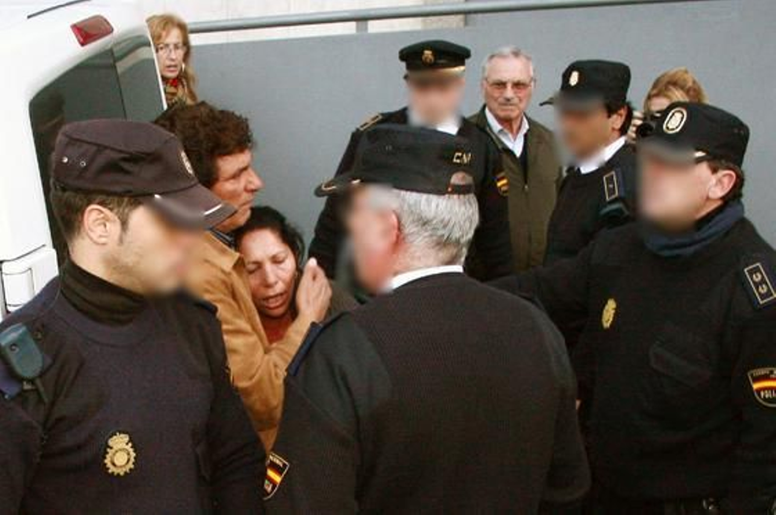 Juan Cortés consuela a su esposa antes de ser detenida por lanzar un paraguas a un furgón policial que transportaba a Rosa del Valle.

Foto: Alberto Dom?uez