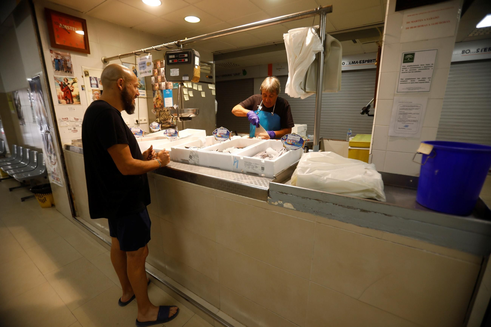 Un pescadero atiende a un cliente en el mercado de Huerta de la Reina