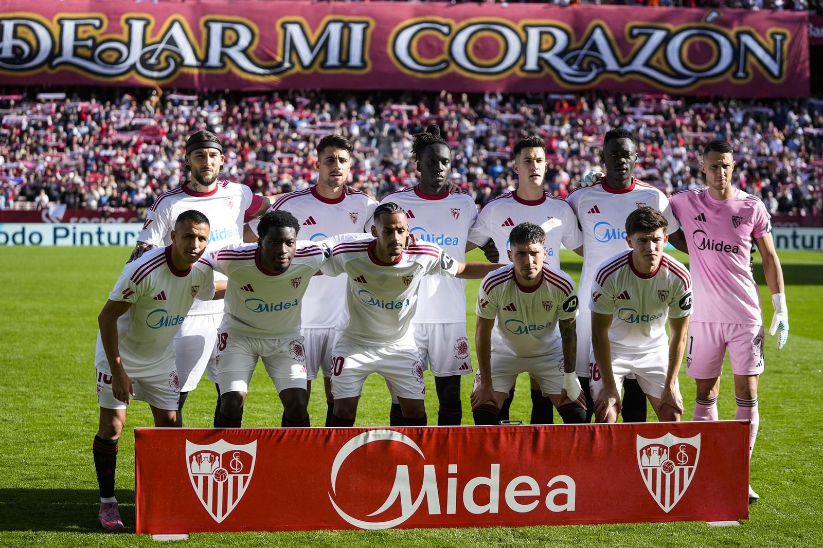 El once inicial del Sevilla con parte del verso de García Barbeito en la grada de Fondo.