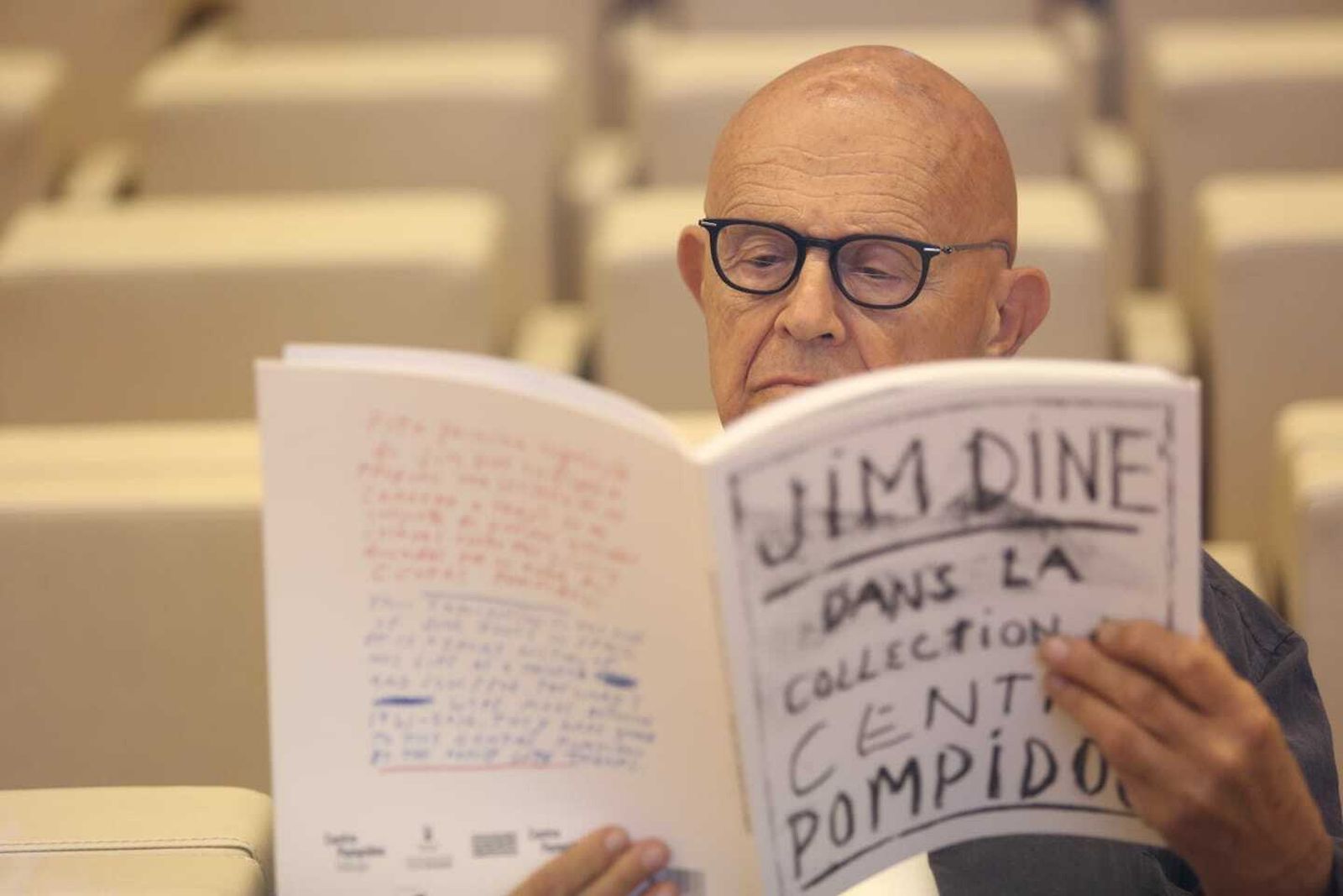 El artista Jim Dine observa el catálogo de la muestra en Málaga.